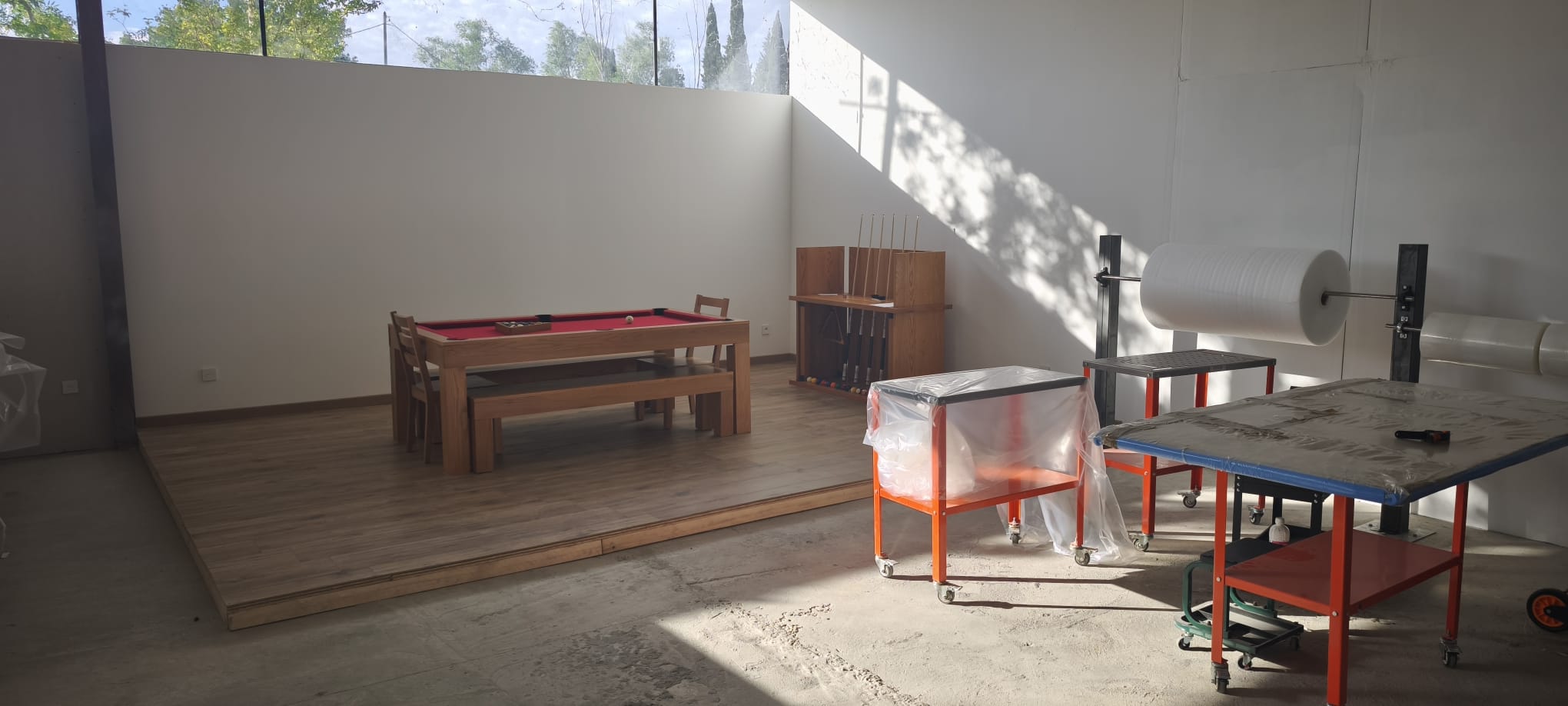 Showroom Billard Brando : billard convertible en chêne massif avec tapis rouge, chaises, bancs et porte-queues Image